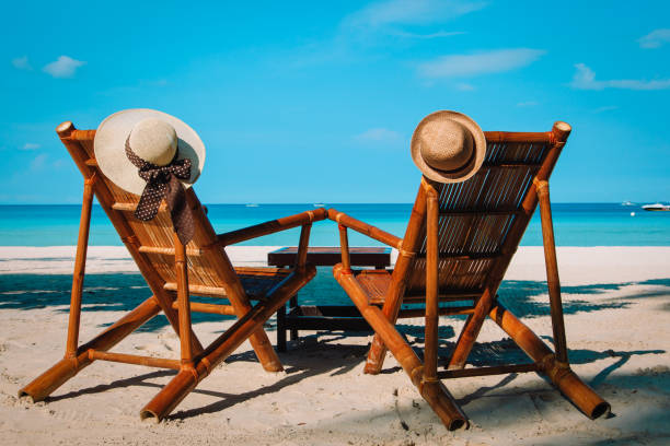 istock hats on chairs of tropical sand beach 670836190
