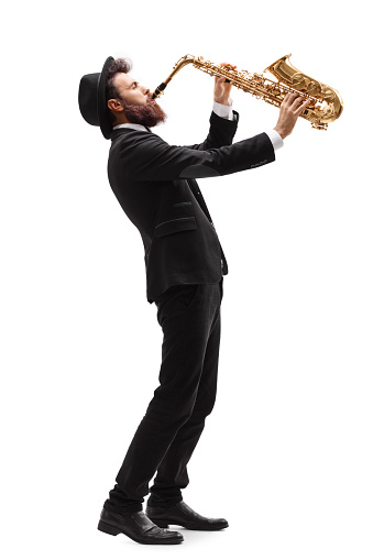 Full length profile shot of a man playing on a saxophone isolated on white background