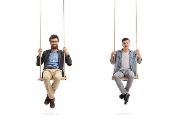 istock Father and son sitting on wooden swings 670839098