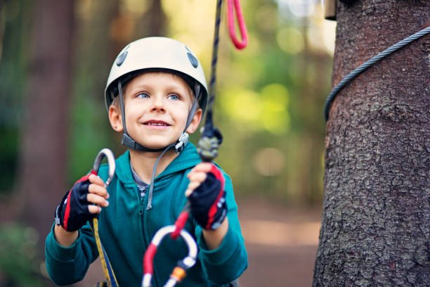istock Little boy attaching carabiner to zip line 670840786
