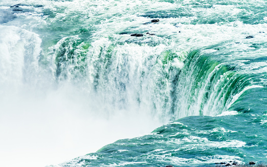 A very high shutter speed used to freeze the motion of torrents of water falling down the Horseshoe Falls at Niagara.