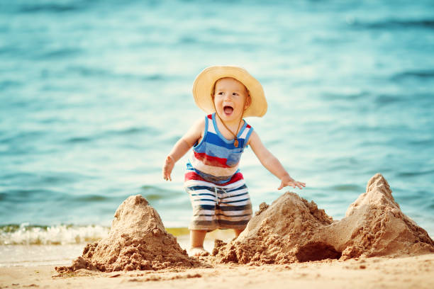 istock little boy walking at the beach in straw hat 670848118