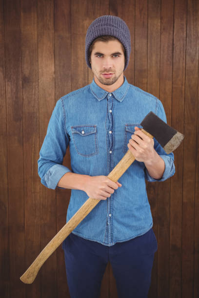 istock Serious hipster wearing knitted hat holding axe 670851572