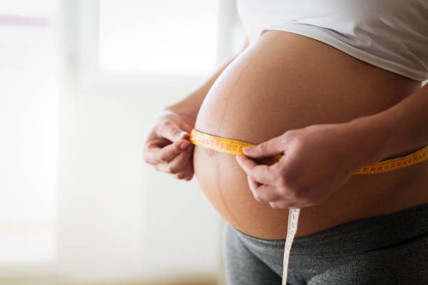 istock Beautiful belly growth during pregnancy beaing measured 670851740