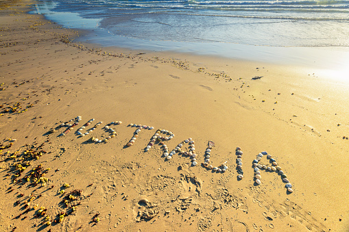 Australia word drawn using shells on sand at the beach