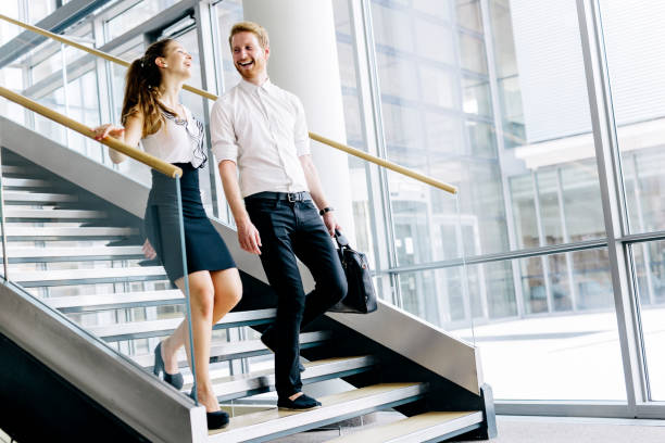 istock Business colleagues talking on stairs and flirting while smiling 670873450