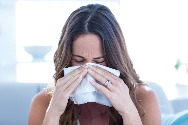 istock Sick woman sneezing in tissue 670874760