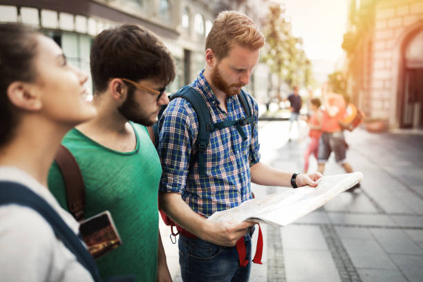 istock Young happy tourists holding map sightseeing in city 670874930
