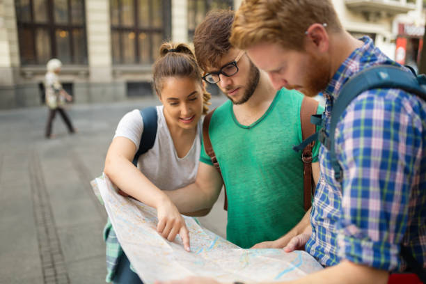 istock Young happy tourists holding map sightseeing in city 670875018