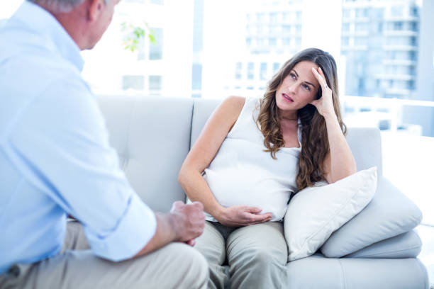 istock Depressed preganant woman talking with therapist 670880572