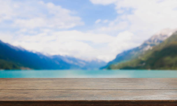 istock Wood table top and blurred lake & mountain background 670880936