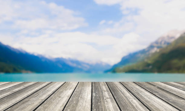 istock Wood table top and blurred lake & mountain background 670883128