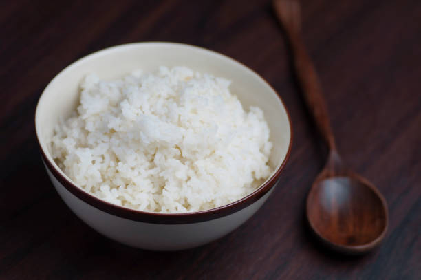 istock Thai rice in bowl with wooden spoon on table 670883344