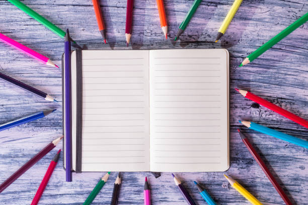 istock Color pencils near note on wooden background. Top view. Copy space. 670887106