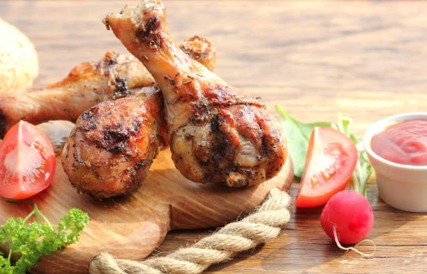 istock Grilled chicken legs on wooden background.Rustic dinner table. 670888686
