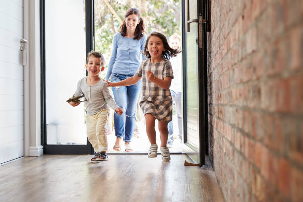 niños muy contentos de llegar a casa con los padres - home interior arrival father family fotografías e imágenes de stock