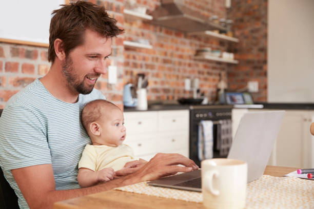 istock Father Working From Home On Laptop With Baby Son 670900824