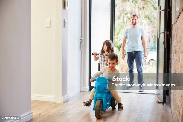 Excited Children Arriving Home With Father Stock Photo - Download Image Now - Family, Opening, Motorcycle