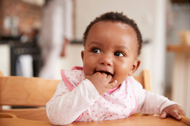 menina bonito usando babador sentado na cadeira alta - high chair - fotografias e filmes do acervo