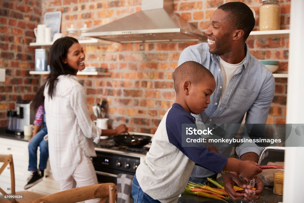 Niños ayudando a los padres para preparar comida en la cocina - Foto de stock de Familia libre de derechos