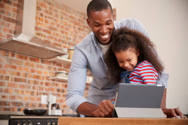 istock Father And Daughter Using Digital Tablet In Kitchen At Home 670901118