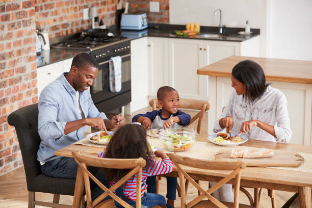 istock Family Eating Meal In Open Plan Kitchen Together 670901130
