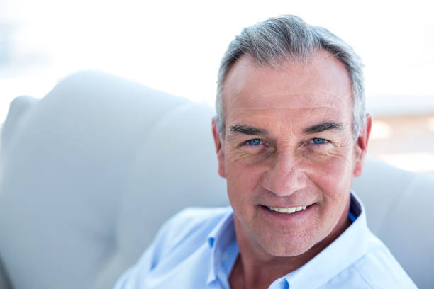 istock Happy man sitting on sofa at home 670902032