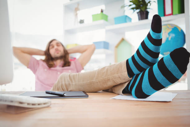 istock Hipster resting with legs on desk 670905154