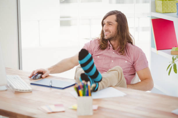 istock Hipster with legs on desk 670905200