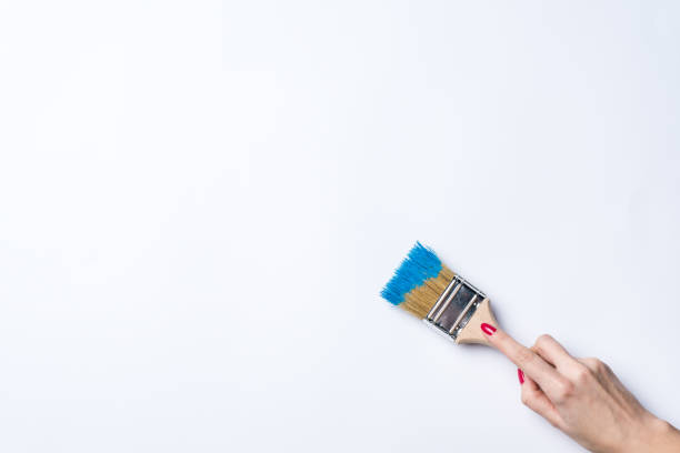 istock Woman painting empty white wall 670905938