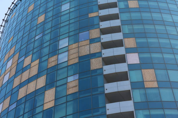 istock Broken windows of a office building boarded up with plywood 670909064