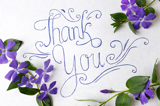 Thank you note surrounded by purple spring flowers