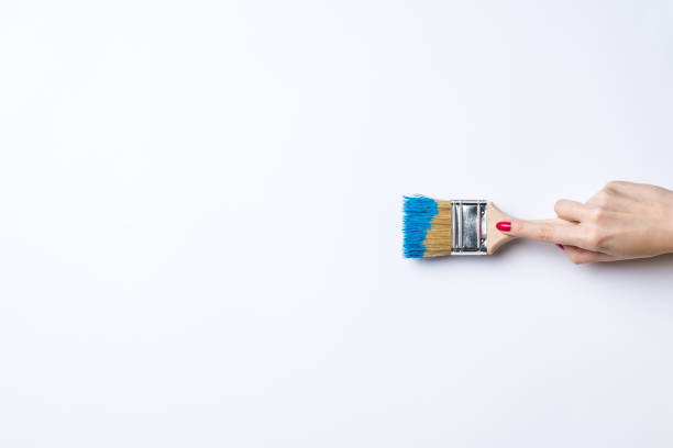 istock Woman painting empty white wall 670912056