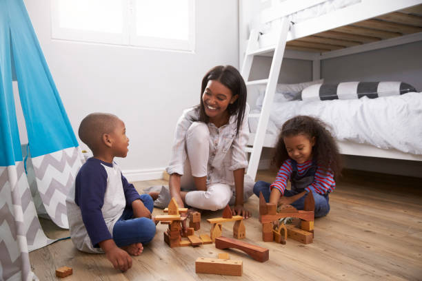 mutter und kinder spielen mit bausteinen im schlafzimmer - tipi bett stock-fotos und bilder