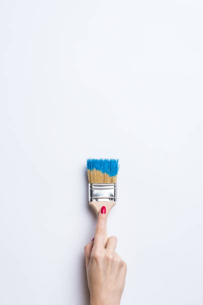 istock Woman painting empty white wall 670920004