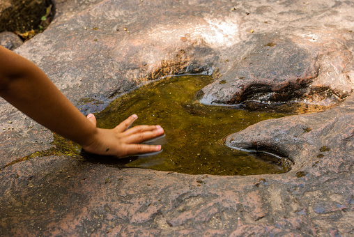 Human footprints with dinosaur footprints on stone floor