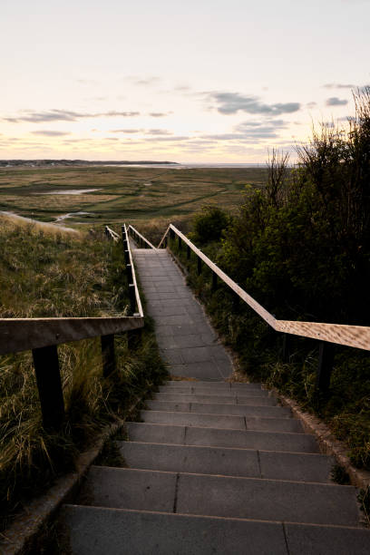 Stairs leading over a dike which are protecting a large area against the raising oceans. The picture is taken on the south end of the island Amager which are very flat and low. It is an important part of the Danish capital Copenhagen