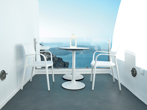 Two chairs and a small table on a beautiful terrace with a wonderful sea view in Santorini - Greece.