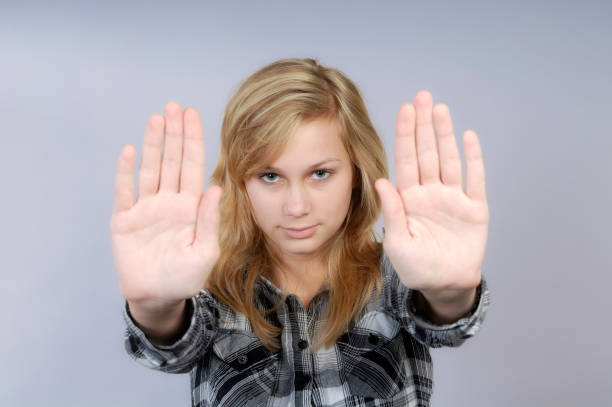 Panicked young girl filled with fear , screaming in terror of her abuser - female abuse concept