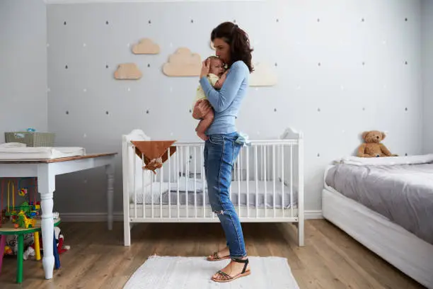 Photo of Mother Comforting Newborn Baby Son In Nursery