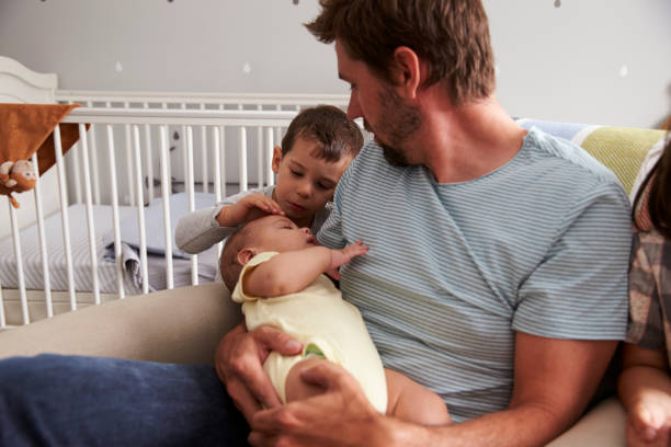 istock Father With Son And Newborn Brother In Nursery 670930428