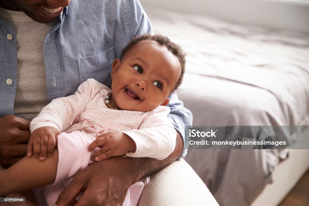 Close Up Of Father Holding Baby Daughter In Nursery Baby - Human Age Stock Photo
