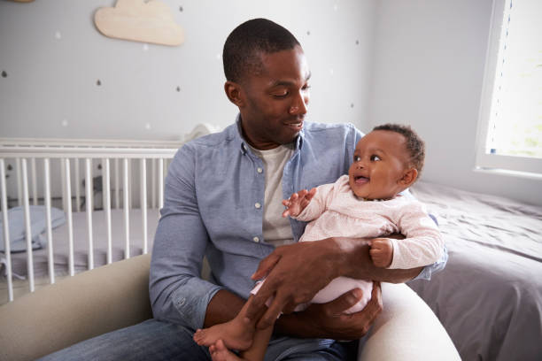 istock Father Holding Baby Daughter In Nursery 670930486