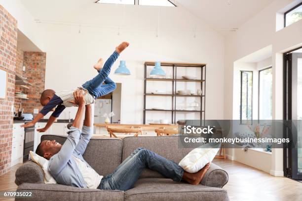 Father And Son Having Fun Playing On Sofa Together Stock Photo - Download Image Now - Family, Living Room, Domestic Life