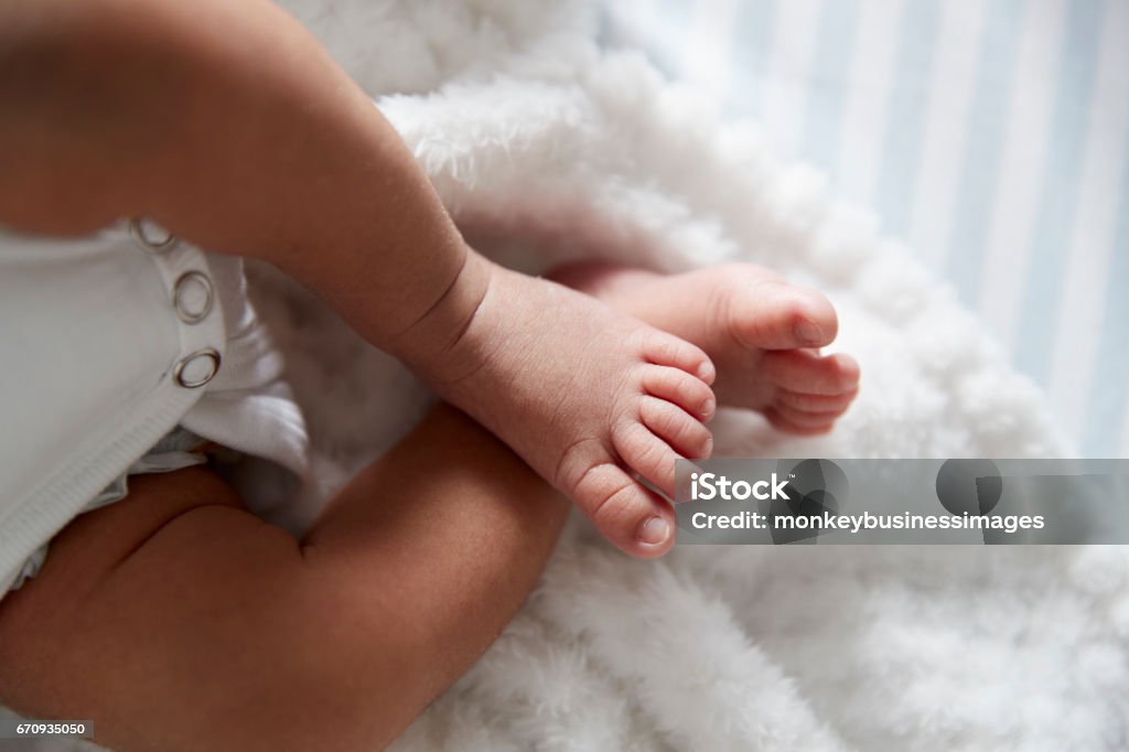 Close-Up dos pés do bebê recém-nascido no berço do berçário - Foto de stock de Pé royalty-free