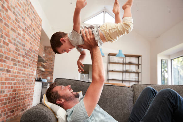 istock Father And Son Having Fun Playing On Sofa Together 670935056