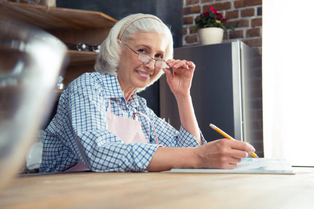 istock Senior woman with cookbook 670937594