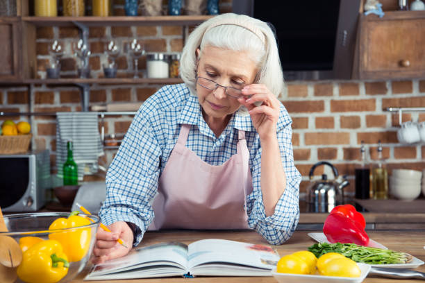 istock Senior woman with cookbook 670937934