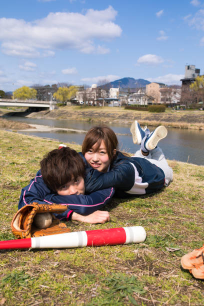istock young athlete couple lying on grass together after playing baseball 670941726