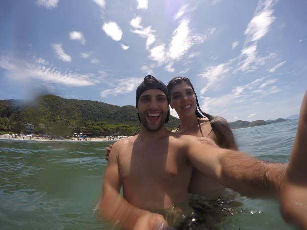 istock Couple taking a selfie and having fun in a Beach in Brazil 670947292